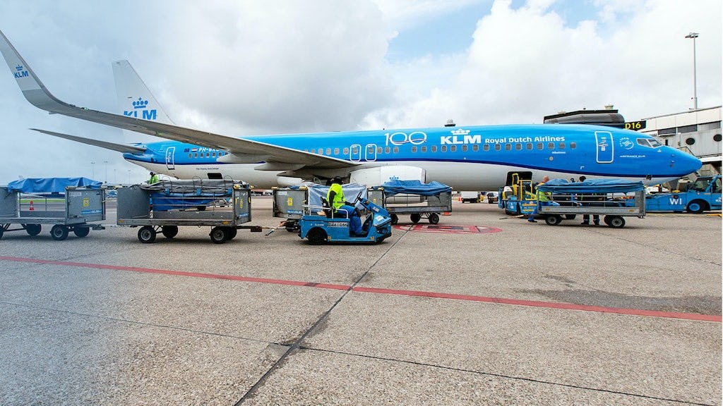 Een KLM vliegtuig staat naast de gate en wordt ingeladen