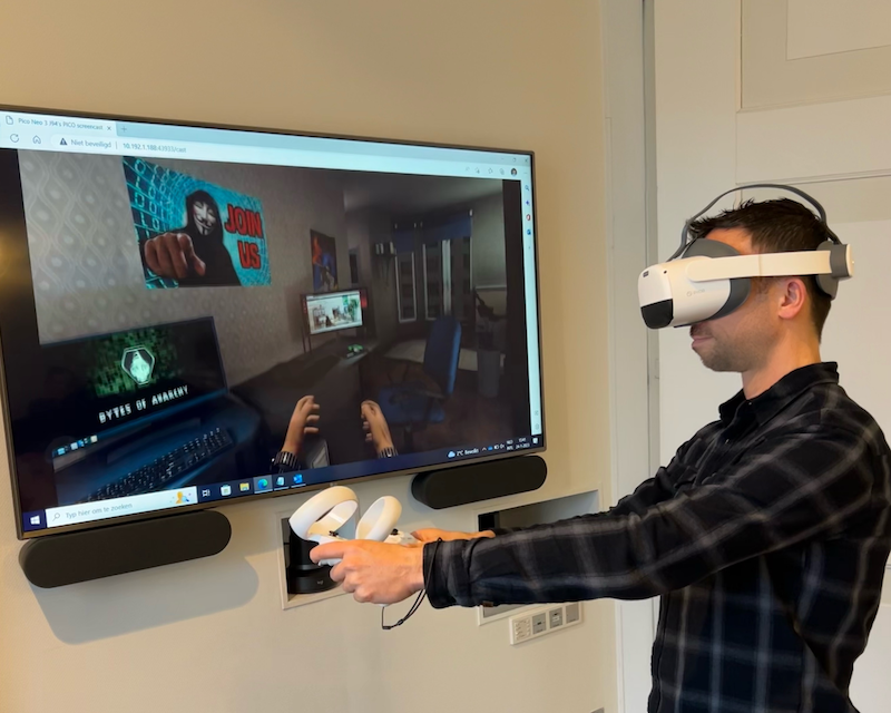 Pascal probeert een VR-oplossing voor de klant uit, met VR-bril op en  controllers in zijn handen